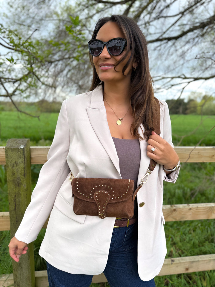 Woman wearing Arabella personalised chesnut brown suede crossbody bag with studded detail