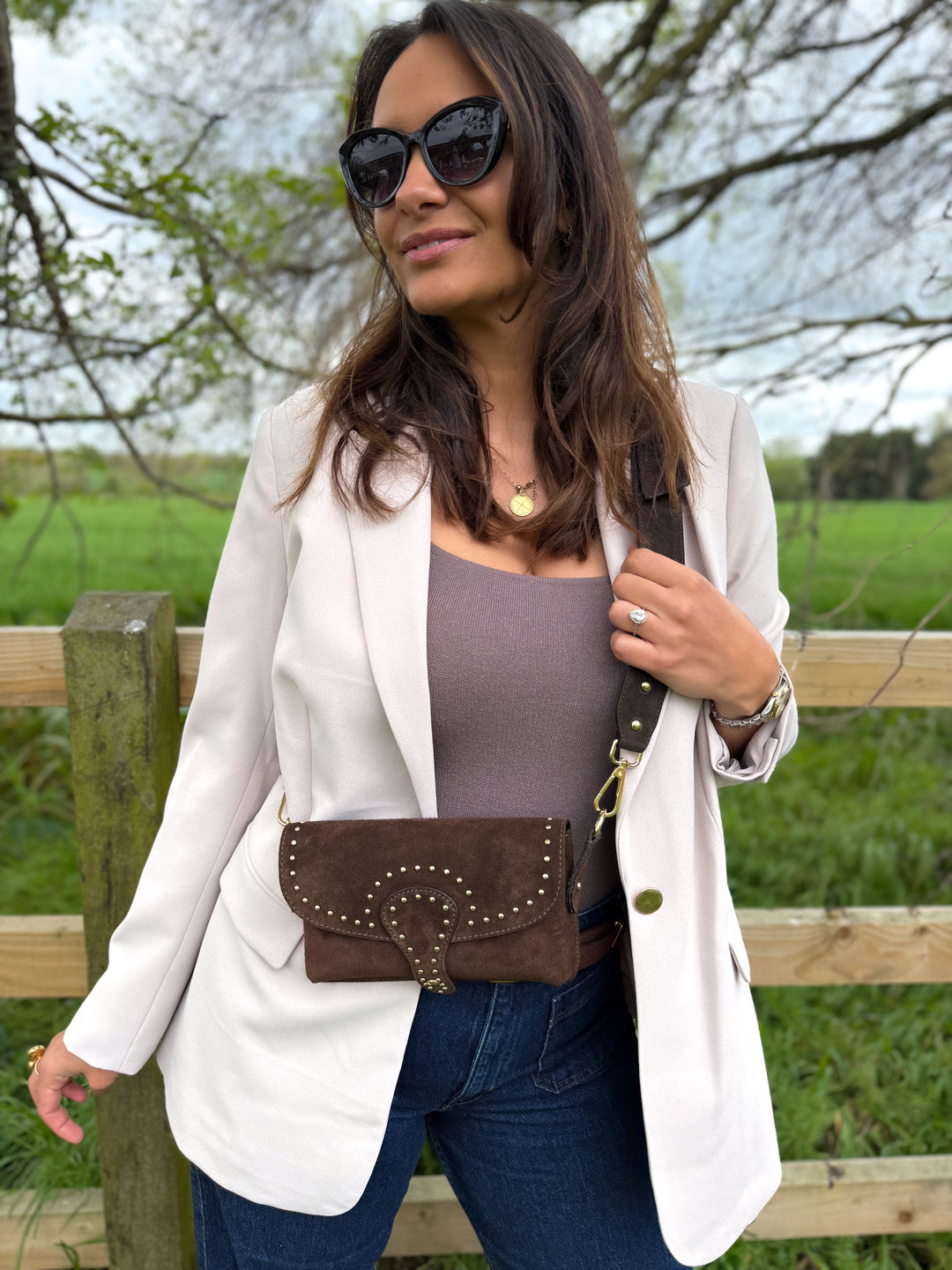 Woman wearing Arabella personalised dark brown suede crossbody bag with studded detail