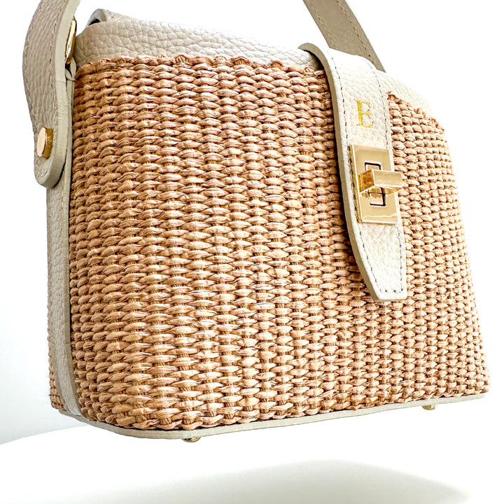 Woven RAFFIA handbag with beige strap on a white background